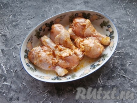 Замаринованные куриные ножки выложить в форму для запекания, влить 3 столовые ложки воды, поставить минут на 15 в духовку, разогретую до 200 градусов, после чего накрыть форму фольгой и запекать мясо уже при температуре 180 градусов минут 40.
