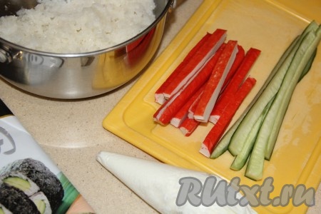 Творожный сыр переложить в кулинарный мешок. Крабовые палочки, заранее размороженные при комнатной температуре, нарезать на длинные брусочки. Огурец вымыть и тоже нарезать на длинные брусочки.
