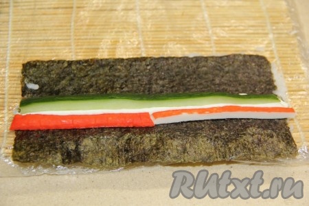 Поверх сыра выложить огурец.
