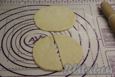 Каждый колобок на присыпанной мукой поверхности раскатать в круг не очень тонко. Каждый раскатанный круг разрезать на 2 части.
