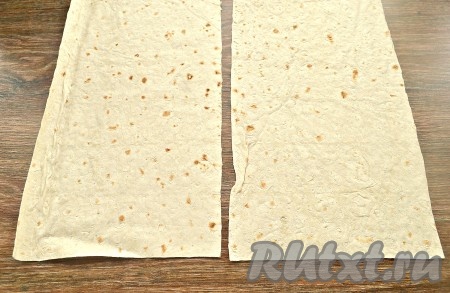 Кулинарными ножницами разрезать тонкий лаваш на две равные половинки.