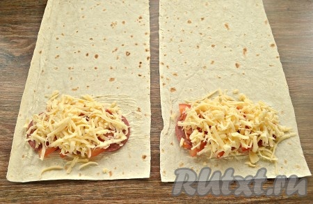 Натереть сыр, присыпать им колбасу с помидорами.
