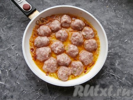 Выложить в сковороду к подливке со сметаной подготовленные фрикадельки.
