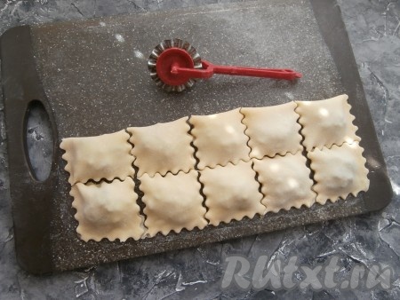 Накрыть начинку пустой стороной теста и фигурным (или обычным) ножом нарезать квадратные равиоли. Если края равиоли плохо скрепляются, аккуратно слепить их пальцами.
