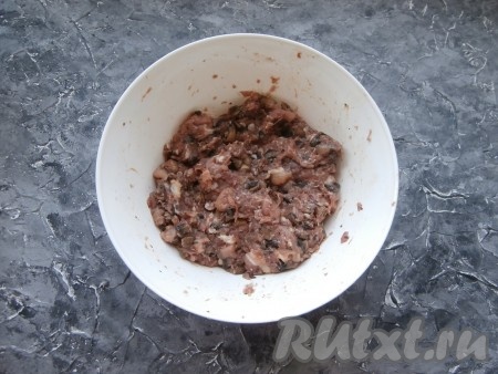 В миску с мясом и грибами влить 50 мл холодной воды и тщательно вымешать получившийся фарш.
