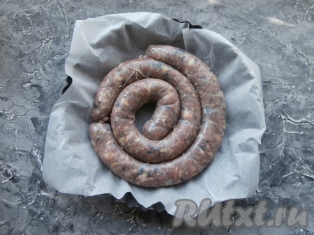 Любую подходящую по размеру форму для запекания застелить пергаментом, который нужно смазать 2 чайными ложками растительного масла. В подготовленную форму выложить домашнюю колбасу с грибами.
