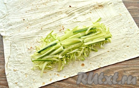 Свежий огурец вместе с кожурой нарезать соломкой и выложить на слой капусты.
