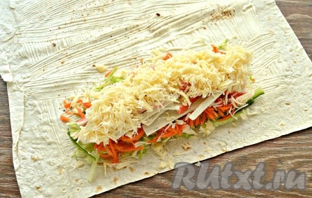 Поверх крабовых палочек аккуратно выложить слой натёртого сыра. Сыр советую натереть на средней тёрке.