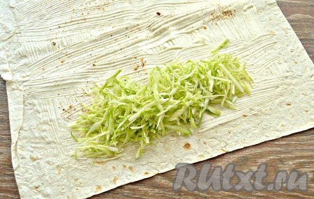 Пекинскую (или молодую белокочанную) капусту тонко нашинковать. Выложить нарезанную капусту на одну сторону лаваша в форме аккуратного четырехугольника.