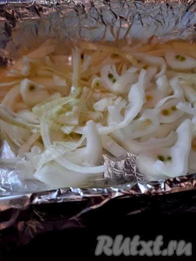Жаропрочную форму застелить фольгой и поверх фольги выложить нарезанный репчатый лук.

