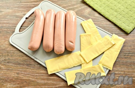 С сосисок снять целлофановую слюду. Плавленный сыр в пластинах разрезать на прямоугольники по количеству сосисок. Вместо плавленного сыра можно нарезать полоски из обычного твёрдого сыра.