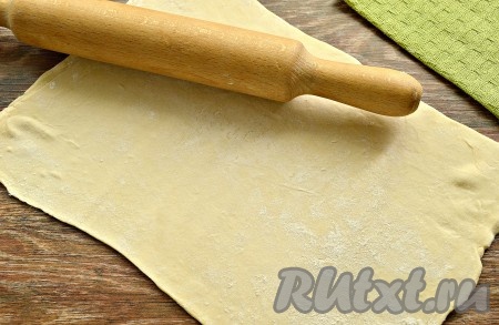 Размороженный пласт слоёного теста выложить на стол, припылённый мукой, и раскатать в одном направлении. Длина получившегося пласта должна быть в 3 раза длиннее размера сосиски.