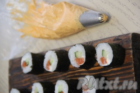 Острым ножом нарезать сформированный ролл на 6 или 8 кусочков. Аналогично сформировать все роллы с авокадо и лососем. У меня получилось 22 штуки.