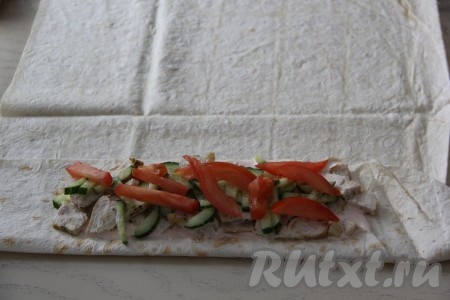 Поверх курицы выложить четверть нарезанных огурцов и помидоров.