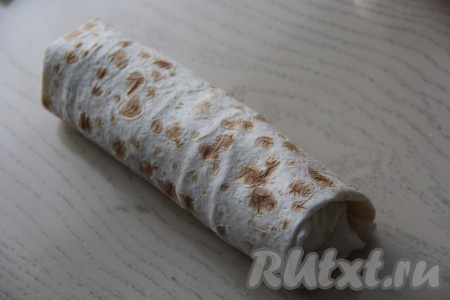 И свернуть лаваш с начинкой в плотный рулет. Таким образом сформировать все 4 шавермы с курицей и овощами.