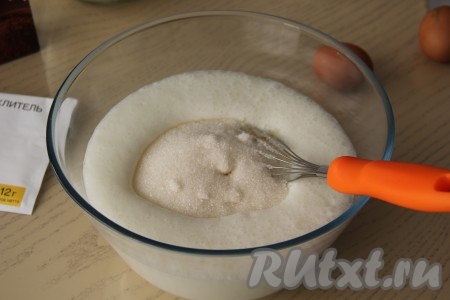Затем в смесь кефира и соды всыпать сахар.