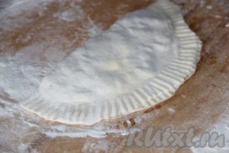 Свободной частью теста накрыть часть с фаршем. Вилкой или руками скрепить края чебурека.