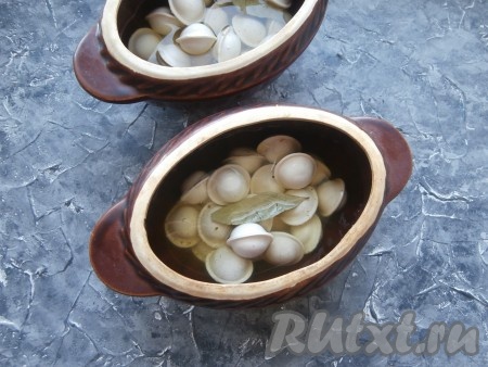 Влить холодную воду (или охлаждённый бульон), которая должна немного покрывать пельмени, добавить по лавровому листу в каждый горшочек.