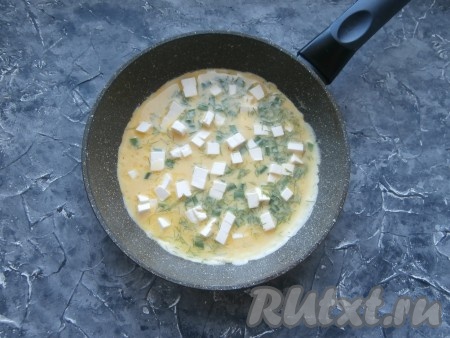 Вылить яично-молочную смесь в сковороду, распределив её по всему дну. Сверху выложить кусочки плавленного сыра.