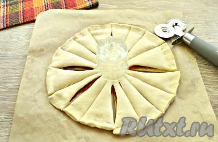 В центр основы пирога поставить рюмку. И, начиная от рюмки, сделать 16 надрезов, разделив пирог на сектора, как лепестки у цветка. Мне удобнее делать надрезы пиццерезкой, можно сделать и ножом.
