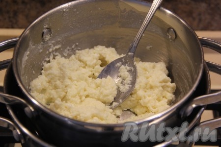 Поставить кастрюлю на водяную баню (для этого нужно взять кастрюлю достаточно большого объёма, вскипятить в ней воду, уменьшить огонь и сверху поставить кастрюльку с творожной массой (она не должна касаться дна кастрюли, поверх которой находится), вода должна на 2/3 покрывать кастрюлю с творожной массой). Водяная баня не позволит творожной массе пригореть.