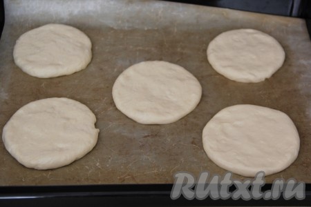 Из теста сформировать толстые лепёшки. Я просто руками, смазанными в масле, разровняла каждую часть теста в лепёшку (без использования скалки). Выложить лепёшки на расстоянии друг от друга на противень, застеленный пергаментной бумагой (или тефлоновым ковриком). Оставить лепёшки на 20 минут под полотенцем.