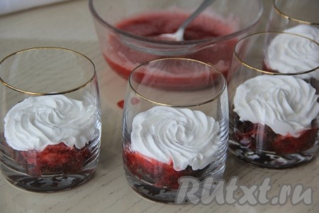 Поверх бисквита выложить по 2 столовые ложки клубничного пюре, затем с помощью кулинарного мешка сформировать слой из взбитых сливок.