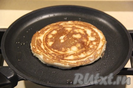 Выпекать банановый панкейк на среднем огне с двух сторон до золотистого цвета, а затем переложить на тарелку. Аналогично приготовить все панкейки.