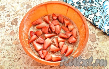 Бока и дно формы для выпечки (у меня диаметр формы 22 см) смазать растительным маслом и присыпать панировочной смесью. Ягоды клубники нарезать на половинки или четвертинки. Распределить клубнику по дну формы.