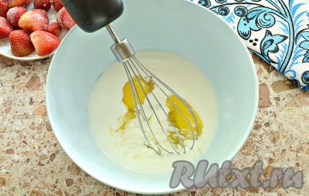 За полчаса до готовки достать клубнику из морозилки, чтобы ягоды немного оттаяли. Когда ягоды оттают, можно приступать к замешиванию теста. В миску влить кефир комнатной температуры, разбить в него куриные яйца, взбить миксером в течение минуты.