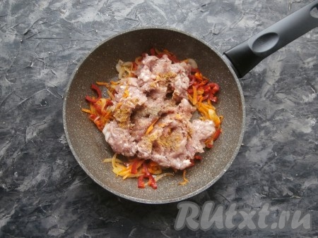 Обжаривать овощи минуты 3, после чего добавить в сковороду фарш, посолить его, всыпать чёрный молотый перец и специи по вкусу.
