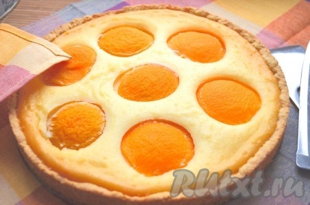 Песочный пирог с консервированными персиками и творогом выпекаем в духовке, разогретой до 190 градусов, 40-50 минут (творожная начинка должна стать золотистого цвета). Готовый пирог достаём из духовки, даём ему остыть не менее 5 минут. Затем вытаскиваем его из формы и оставляем до полного остывания.