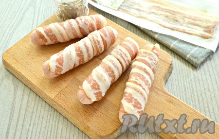 Каждую сосиску обернуть по спирали полоской бекона. Мне хватило одной полоски. Но если у вас сосиски длинные, то возьмите 2 полоски бекона.