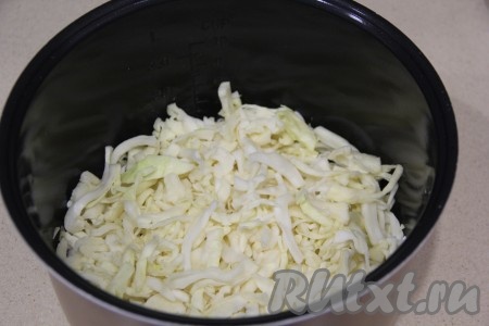 Капусту тонко нашинковать и добавить в чашу мультиварки к рису с луком.