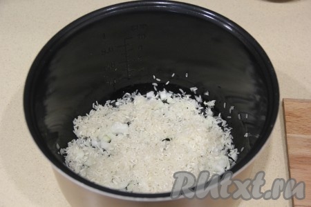Затем к обжаренному луку всыпать рис, перемешать.
