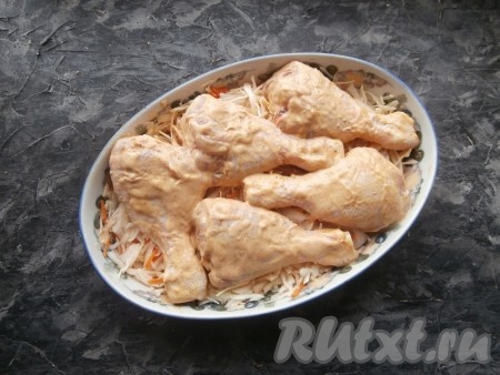 Тщательно перемешать куриные ножки с приправой и соусом, затем разместить их в один слой поверх капусты.