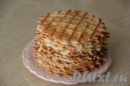 Таким образом, продолжая чередовать домашние вафли и крем, сформировать высокий торт. Я формировала тортик, пока не закончился крем. Немного вафель ещё осталось. Верхнюю вафлю смазывать кремом не нужно. Поставить вафельный торт в холодильник минимум на 5 часов (я оставила в холодильнике на ночь).