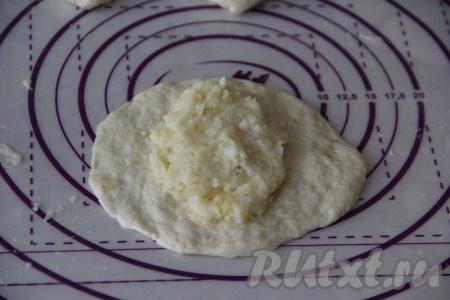 На каждый сформированный круг из теста выложить по 1 столовой ложке картофельной начинки.