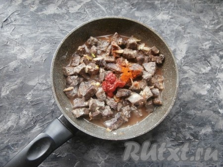 Влить горячую воду, добавить томатную пасту и паприку.