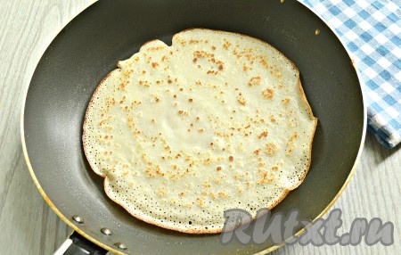 Поверхность сковороды смазать растительным маслом и поставить на огонь. Когда поверхность сковородки очень хорошо прогреется, можно приступать к выпечке блинов. Зачерпнуть половником тесто, распределить тесто по дну сковороды. Печь блин с двух сторон до румяности (приблизительно, по 45 секунд с каждой стороны), затем переложить на тарелку. Я смазывала сковороду маслом только перед первым блинчиком. Аналогично пожарить все блины, складывая их горочкой на тарелку. Блинное тесто в миске перед выпечкой блинов нужно периодически перемешивать. У меня получилось 12 блинчиков (диаметр моей сковороды - 18 см). Этого количества хватит на 3 мини-пиццы.