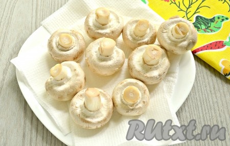 Свежие шампиньоны очистить от загрязнений, ополоснуть аккуратно под холодной водой. Затем выложить грибы на бумажные полотенца, чтобы убрать влагу. Отставить шампиньоны пока в сторону.