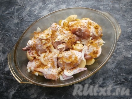 Курицу вымыть, нарезать на произвольные кусочки, посолить и посыпать приправой для курицы, хорошо перемешать. Луковицу очистить, нарезать произвольно и выложить поверх картофеля, добавить мелко нарезанный чеснок и кусочки курочки. 