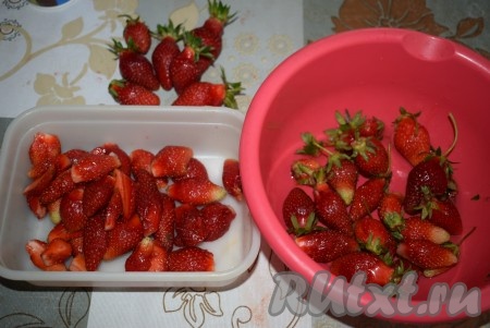 Отберём 6-7 самых красивых ягод для украшения десерта. Оставшуюся клубнику разделим на 2 равные части. Одну часть будем измельчать в блендере вместе с творогом, а другую - нарезать на кубики и добавлять в десерт. Удалим у клубники плодоножки.
