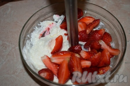 Добавляем к взбитому творогу половину клубники и ещё раз взбиваем блендером до однородности.