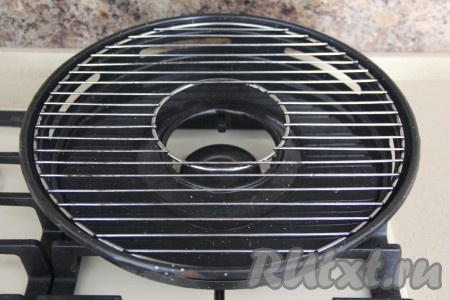 Сковороду поставить на газ так, чтобы круг в сковороде был чётко по краю газа. 200 мл воды влить в сковороду. Установить поверх сковороды решётку.