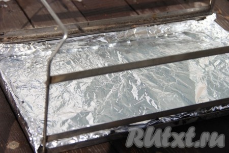 Лист фольги выложить поверх щепы, затем сделать в фольге отверстия.