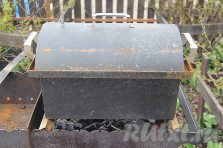 Накрыть коптильню крышкой и поставить на мангал с раскалёнными углями.