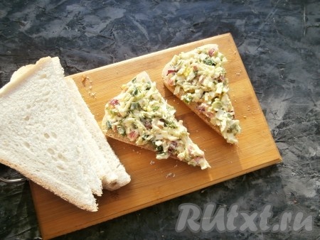 Выложить крабово-яичную смесь на ломти хлеба (или батона).