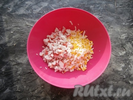 Яйца заранее сварить (варить нужно минут 8-10 с начала кипения воды), затем залить холодной водой, чтобы они остыли и очистить. Размороженные и очищенные от слюды крабовые палочки мелко нарезать, добавить варёные яйца, натёртые на крупной тёрке.