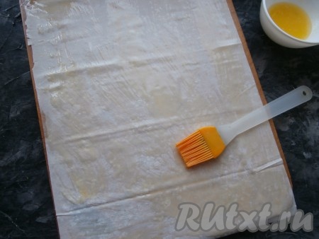 Лист теста фило разложить на доске, смазать хорошенько растопленным сливочным маслом.